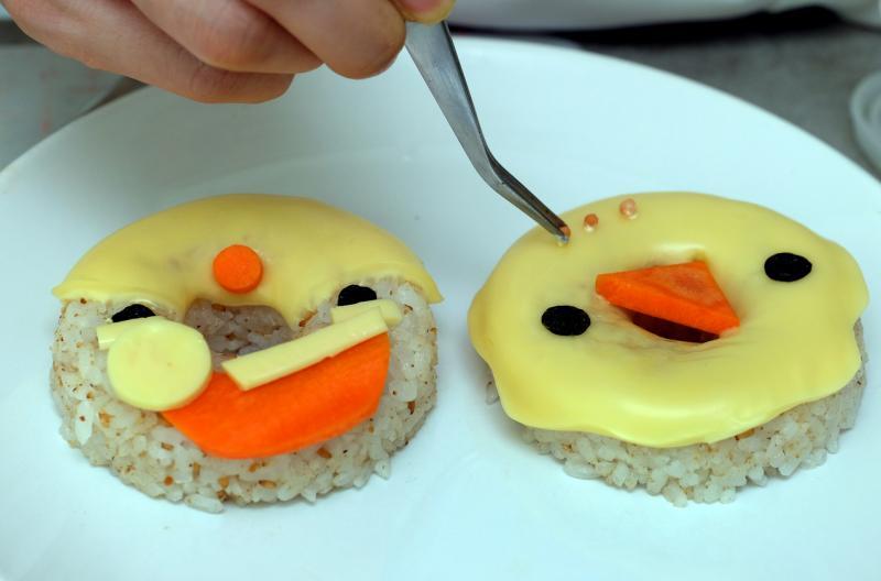 把芝士披在芝麻饭上再装饰雪人的脸。