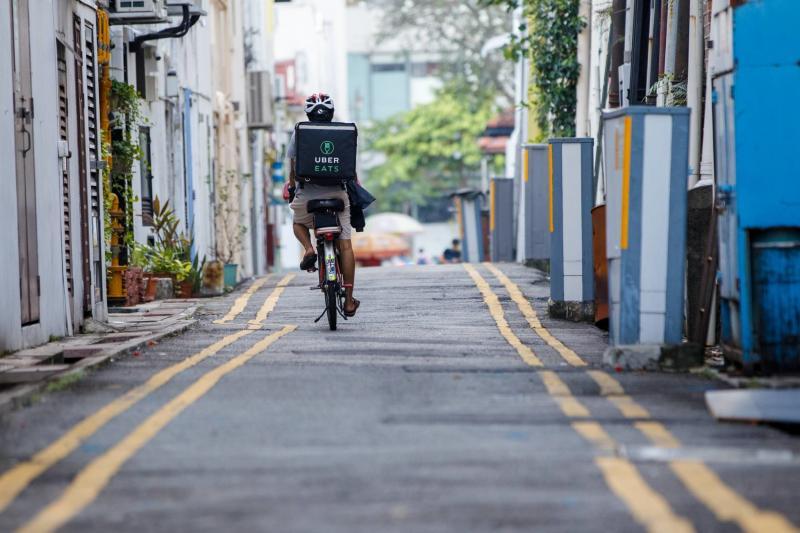 外卖递送员骑脚踏车送餐，用空闲时间为自己轻松赚外快。
