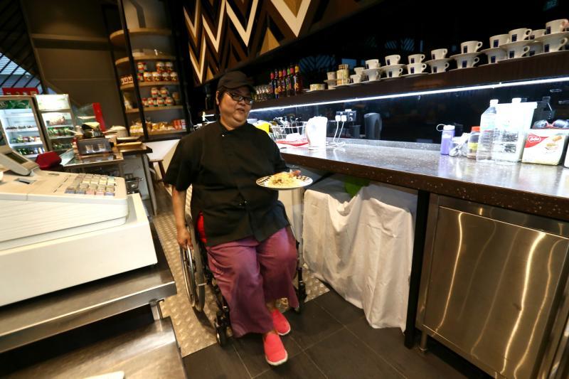 何俐莲利用坡道从柜台后方快速穿梭到厨房。