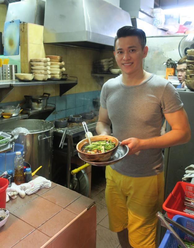 卓汉隆在德明路熟食中心经营田鸡粥小贩档口，不时有一些本地艺人来光顾，生活过得踏实。（受访者提供）