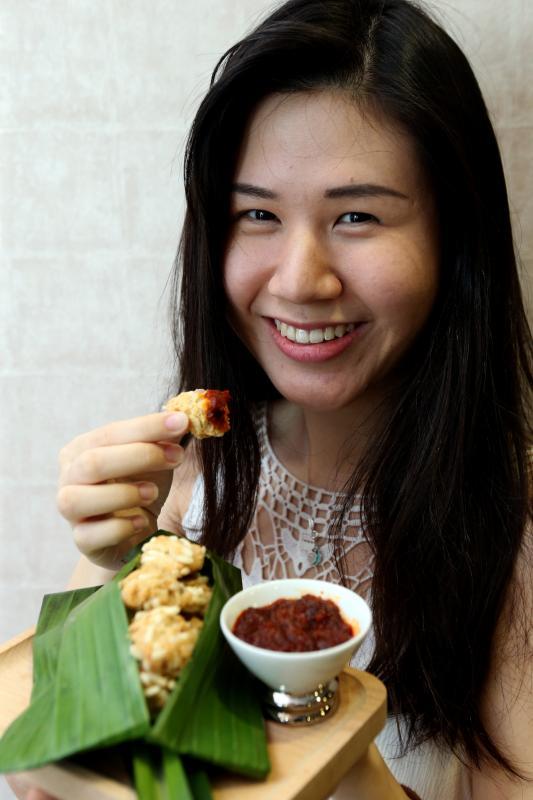 蘸着参峇酱吃椰浆饭曲奇饼的方式充满趣味。(邝启聪摄)