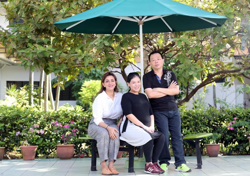 在资深职能治疗师Mellishia Kaur Hoondal（左一）和高级执行护士吴艾思的帮助下，长期住院者黄伟雄（右一）开始工作，康复情况良好。（陈来福摄）