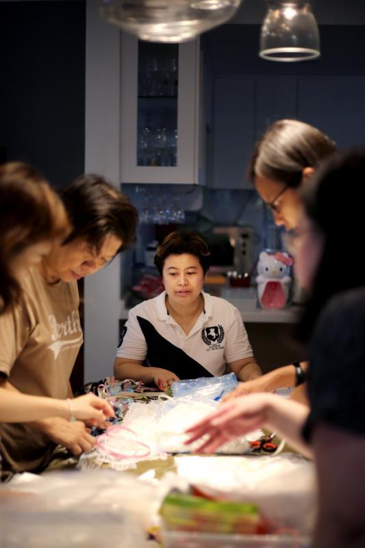 “天使之心”的志愿者们定时聚会,缝制与分发天使礼服。中为陈芳凌。