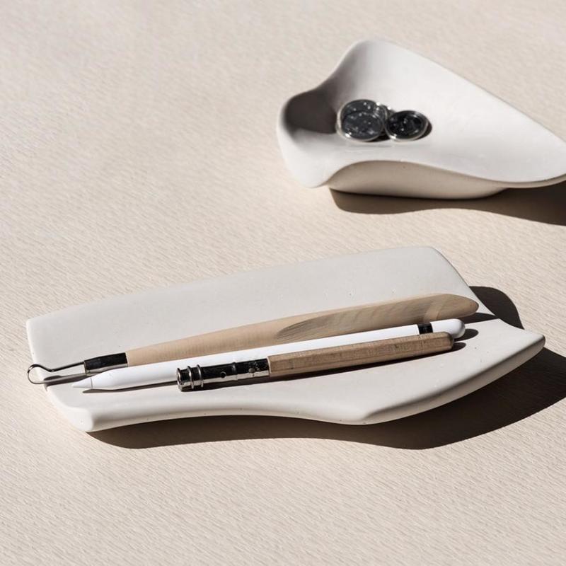 王一龙探索制作有机形状的碟盘,在开着的水龙头下将水泥磨得像肌肤般柔滑。