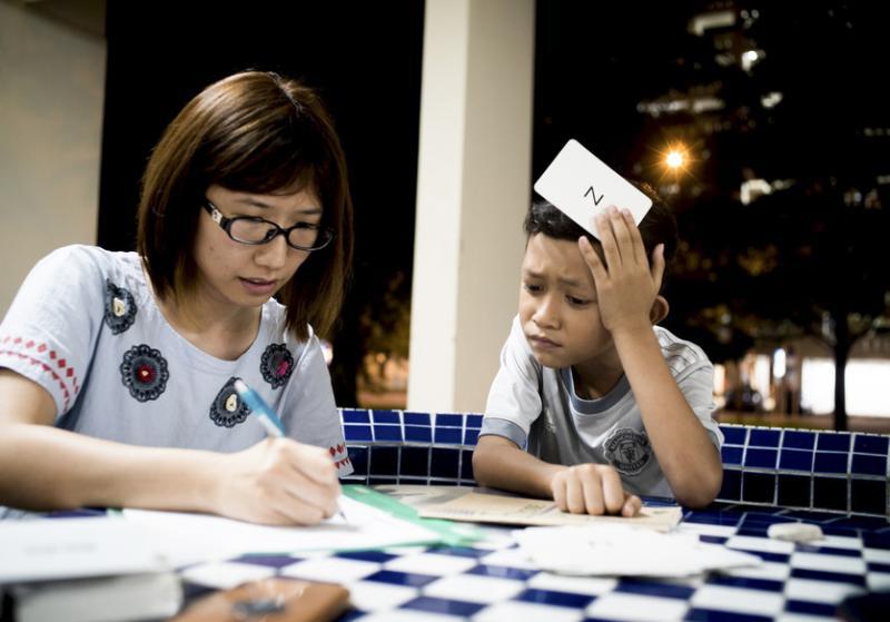 Alif(右)全神贯注地跟大姐姐廖慧雯学英文。(黄淑芬提供)