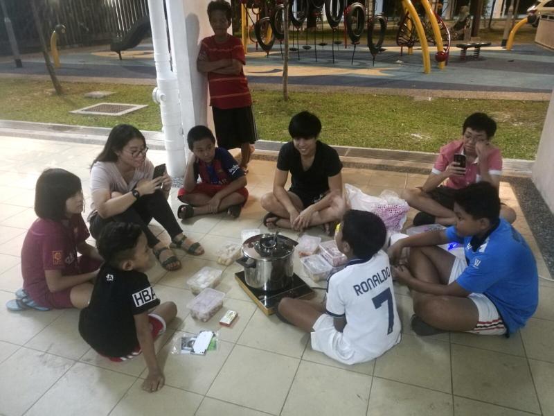 组屋底层成了他们的“俱乐部”。今年过年,大姐姐们为孩子们准备清真火锅大餐。(黄淑芬提供)