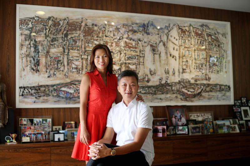 本地藏家傅文克(右)和太太李慧怡住家墙上挂有林子平驳船码头的作品。