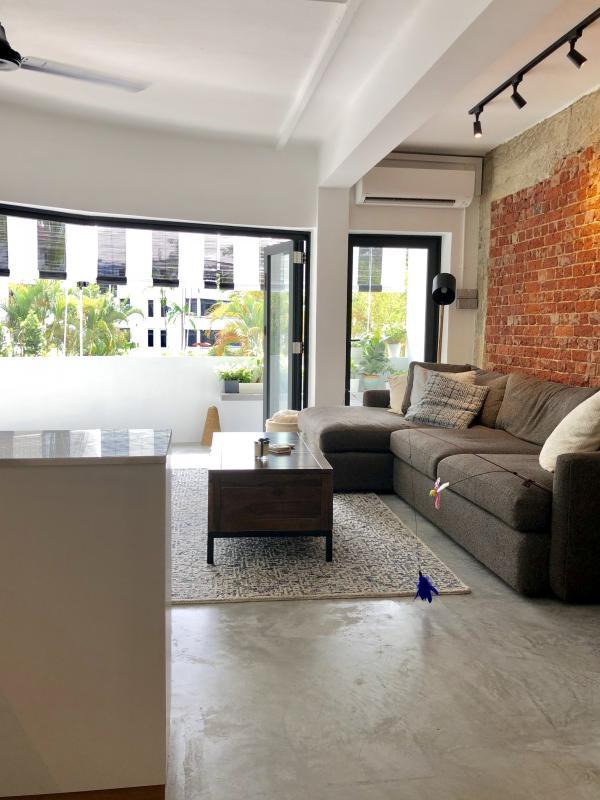 从有红砖墙的客厅望向弧形阳台，给单位带来一种“全景”的感觉，一眼望出去是对面的公园和其他旧组屋。