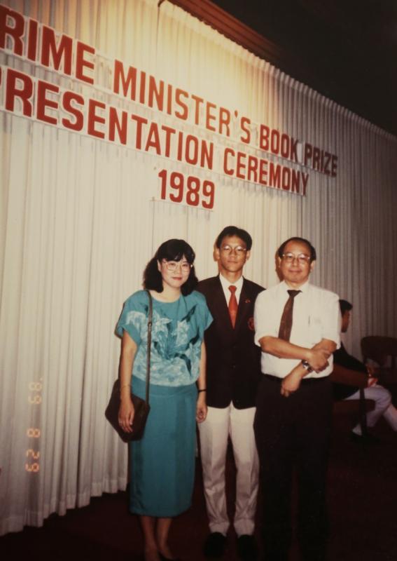 1989年,何国元(中)获颁总理书籍奖与父母合影。(受访者提供)