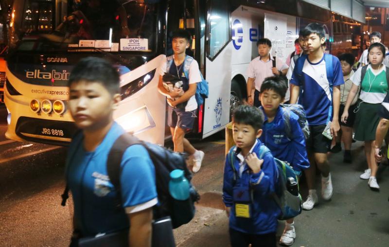 学生在黑暗中下车,以熟悉的步伐往专用通道移进。