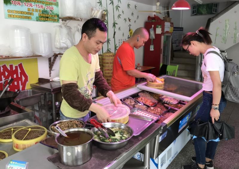 蒸笼饭的配料很多,顾客选好料后店家放进蒸笼里。