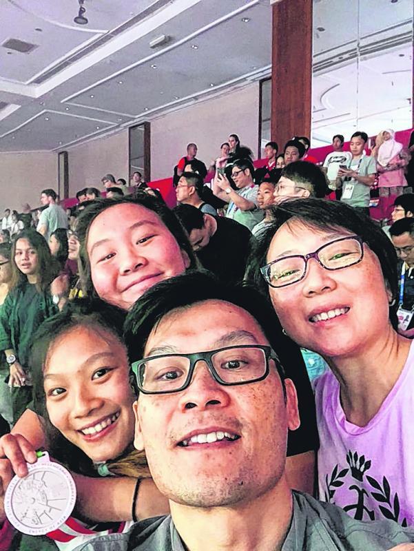 连天恩（左一）在今年的亚运会上获得银牌后，与父母（前排中和右一）和妹妹连天仪（后排）开心合影。（受访者提供）