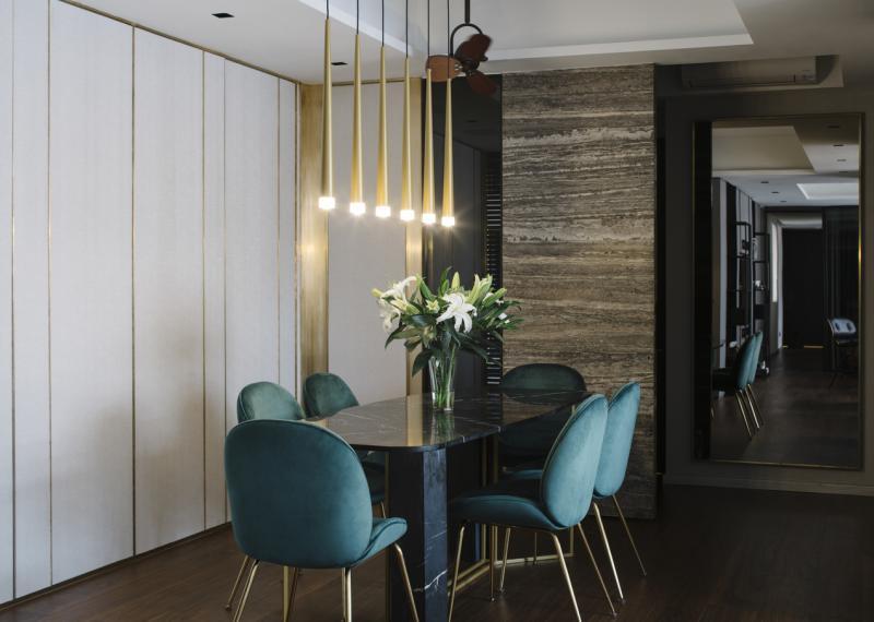 饭厅使用黄铜、大理石、核桃木和翠色绒面面料打造。