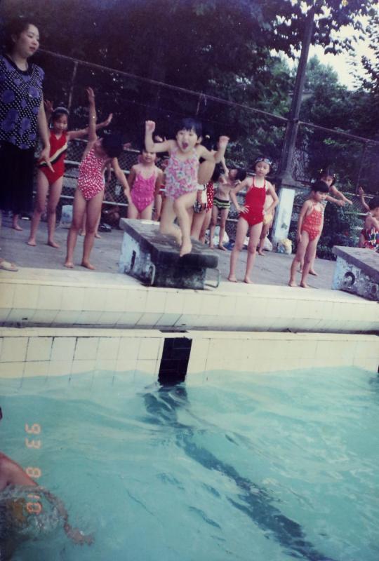 陶李3岁时在母亲李艳的游泳课上玩闹学游泳。（受访者提供）