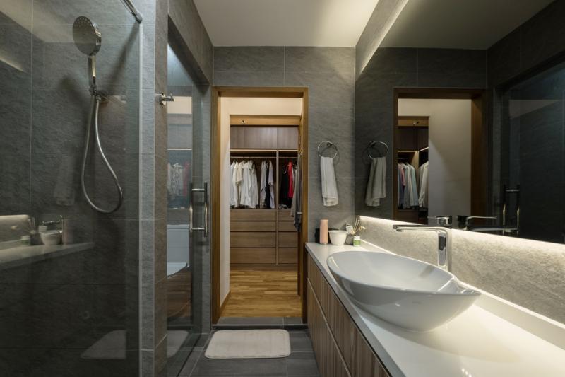 设计师巧妙地让浴室和主人房共用储物空间,将电视机下隐藏的储物柜“吃进”隔壁洗脸盆下的双层橱柜。