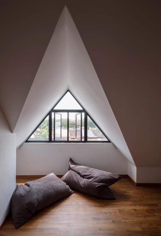 顶层阁楼前方使用斜尖屋顶,打造出一个温馨舒适的私密客房。