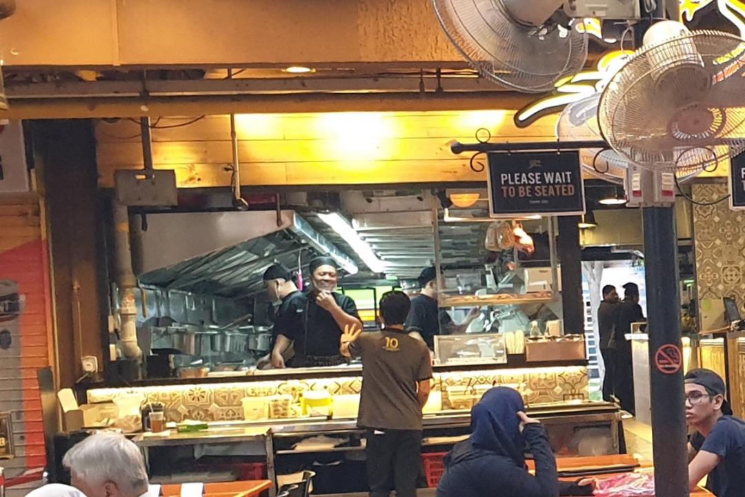 勿洛分店是开放式厨房,厨房员工准备食材时都戴着口罩和手套。(梁麒麟摄)