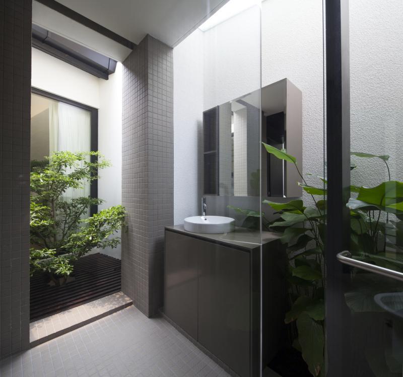 主卧室的卫浴间也移入新楼塔,天窗引进阳光突显小庭院绿意。