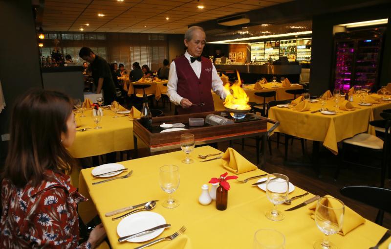 Shashlik的服务生符策传推着餐车到食客面前烹煮甜品。(刘启成摄影)