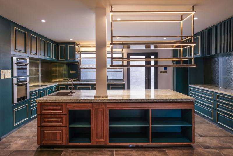 厨房是女主人的天地,于是壁橱和中岛橱柜的深绿色,以及饰边做了更细致和女性化的处理。