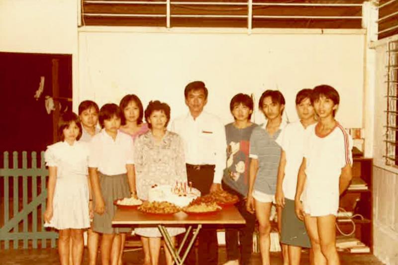 洪菁云（前排左一）与父母（左五及六）和哥哥姐姐们合影，当时的她念小学三年级。（受访者提供）