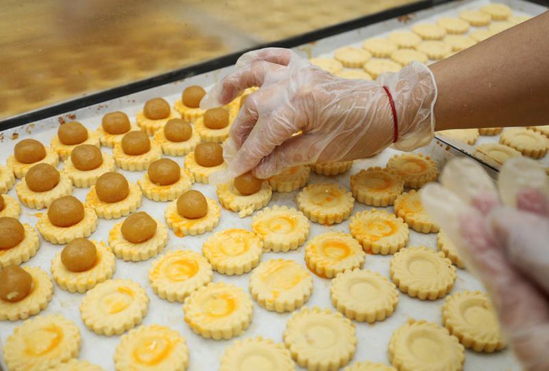 “一口味”糕饼师傅用模具压出太阳花形后放上黄梨酱。(林泽锐摄)