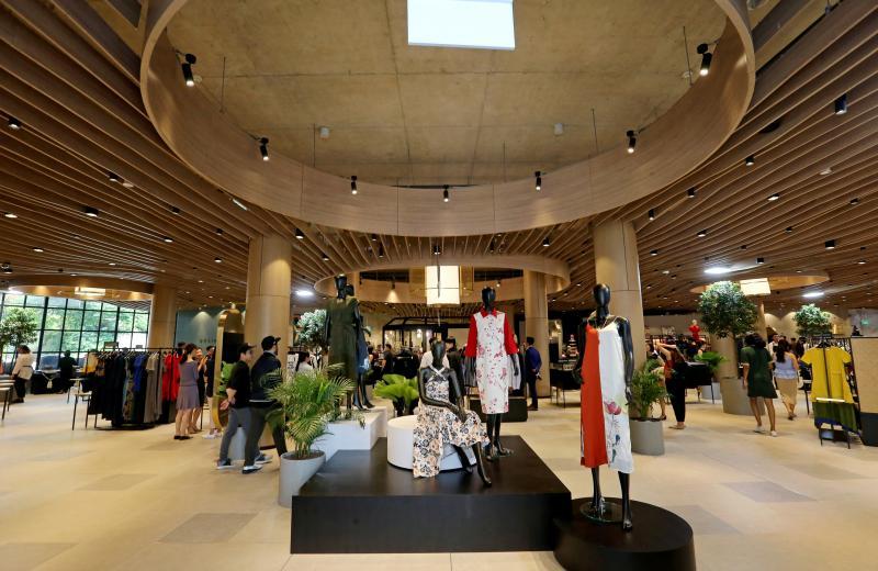 天花板上流线的木条像抽象的树冠和树荫,让买家宛如走在一座花园里购物。