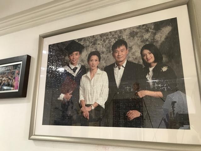 父母把洪凌和她在戏中家人的照片和拼图，挂在家中客厅，传达大爱精神。