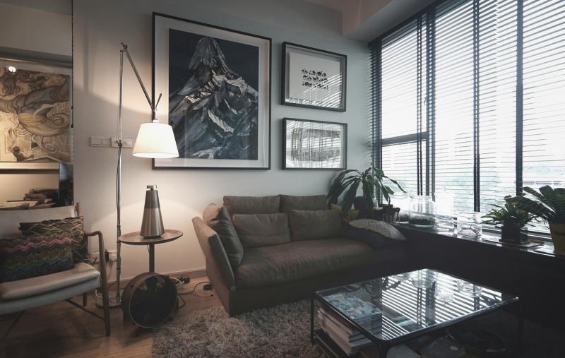 深沉柔和的客厅也是屋主的艺廊,墙壁和不同角落挂满与摆设了屋主从世界各地带回来的艺术品。