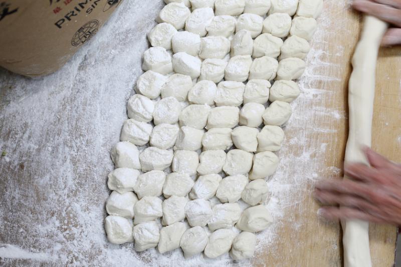 师傅手工拆面,凭手感和经验把面团分成均匀小块。(龙国雄摄)