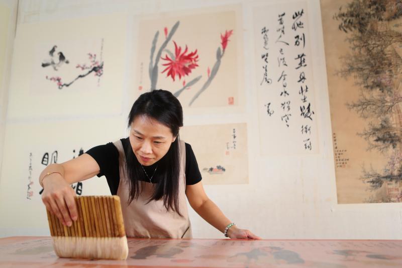 学商的张艳从小就在父亲修复书画的工作台兜转，她从熬浆糊、磨刀开始到今日全神贯注进入画里，看见文物活起来，气韵生动。