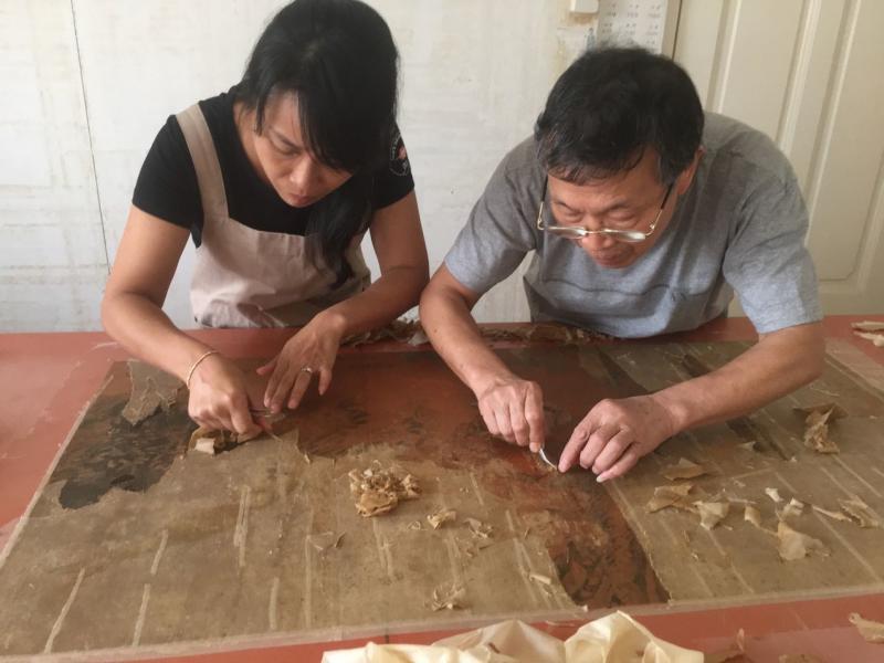 揭裱是修复过程中最关键的一步，丝毫不能分神。（受访者提供）
