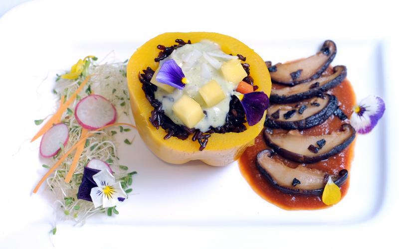 健康宝盒（主食）：发芽黑米饭盛在黄色灯笼椒上，配上少许新鲜香芒和风干椰片以提味。左边伴以少许苜宿芽、小黄瓜和可食用花瓣，右边则有香菇片铺在自打的番茄酱上。