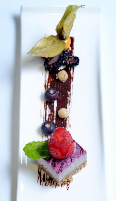 能量甜点：草莓慕斯铺在揉压而成的杏仁坚果饼上，伴以榛果、蓝莓、覆盆子，底下是有机生可可打成的巧克力酱。