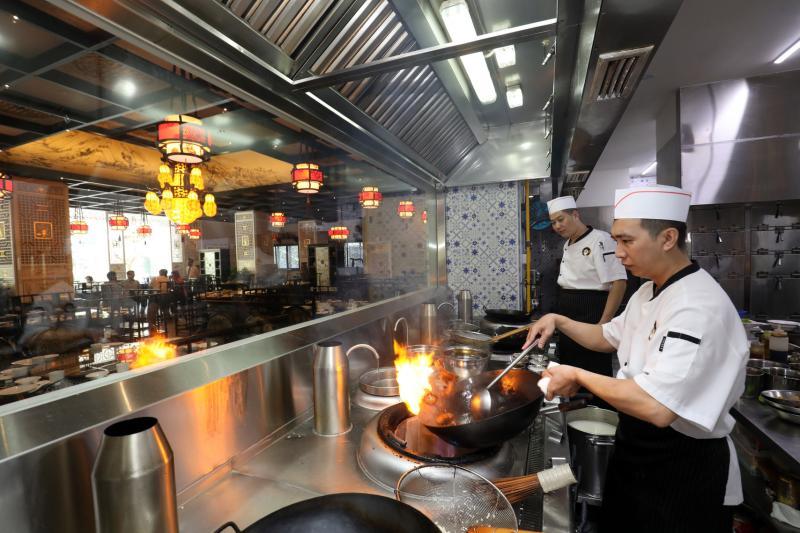 品珍宫厨师在有冷气的厨房里做菜，环境较舒适。