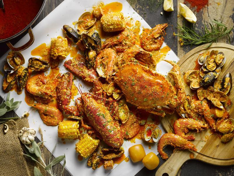 把海鲜摊开在桌子上，桌子铺上特制纸张，和亲友聚餐一起动手吃海鲜。