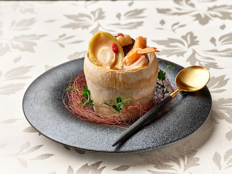 椰皇干贝生虾花菇鲍鱼炖鸡汤,椰盅保持汤的温度。