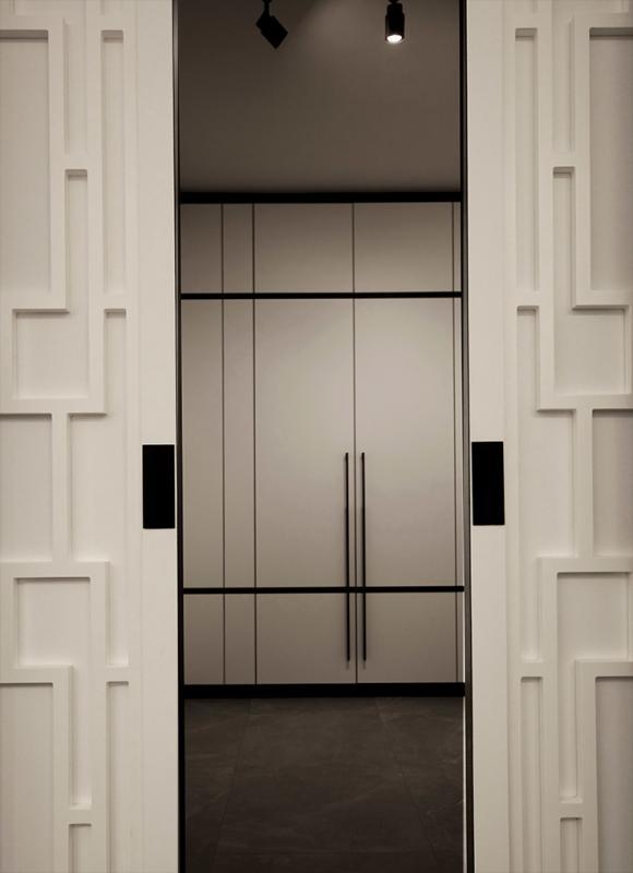 拉开中国门框趟门,即见三面白面黑边的落地衣橱。