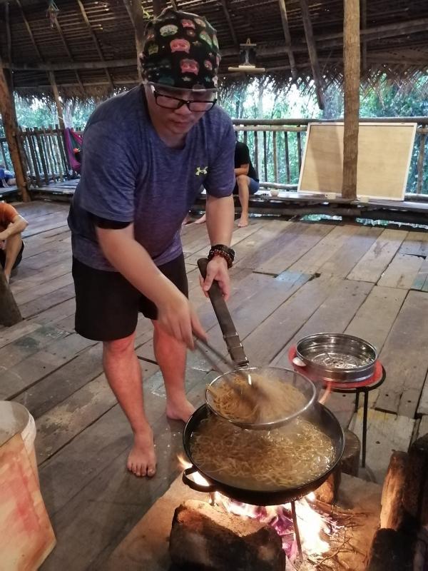 民宿员工砍柴生火,水烧开后再煮汤烫面。(受访者提供)