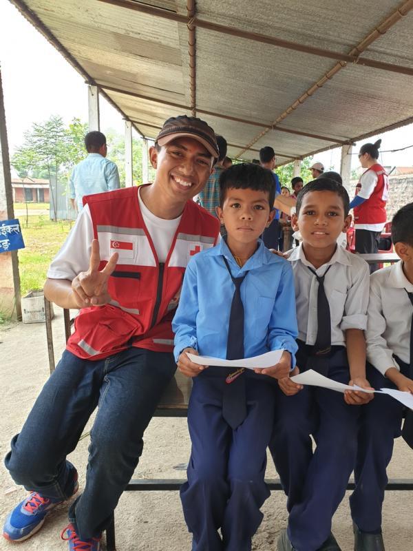 莫哈默·阿希克(左一)与新加坡红十字会国际服务团队与尼泊尔展开人道救援任务时,为经历地震的当地孩子提供心里急救。(受访者提供)