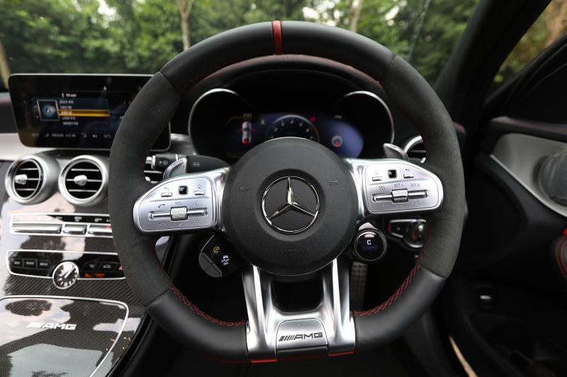 平底的跑车式方向盘,右边设有让司机转换驾驶模式的操控按钮(C)。