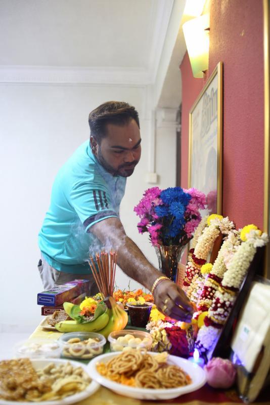 卡迪和家人在屠妖节前祭拜祖先，邀请祖先一同欢庆佳节。（龙国雄摄）