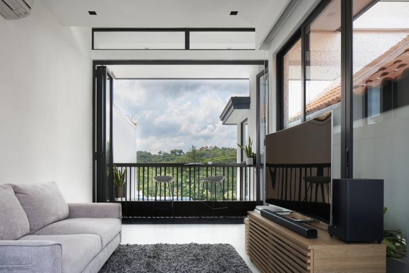 攀上饭厅后的楼梯,便来到上屋的客厅,阳台外能看见南方山脊的绿意盎然。