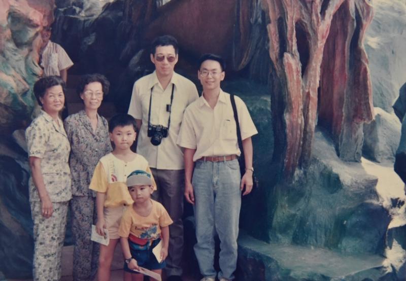 苏章恺(较大的孩子)在叔叔苏春兴(右一)的陪同下,与祖母、外婆、弟弟到虎豹别墅游玩,与时任贸工部部長的李显龙(右二)合影。(受访者提供)