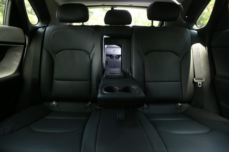 后座中央扶手有两个杯架，还有个可拉下的小口，方便司机提取小物品。