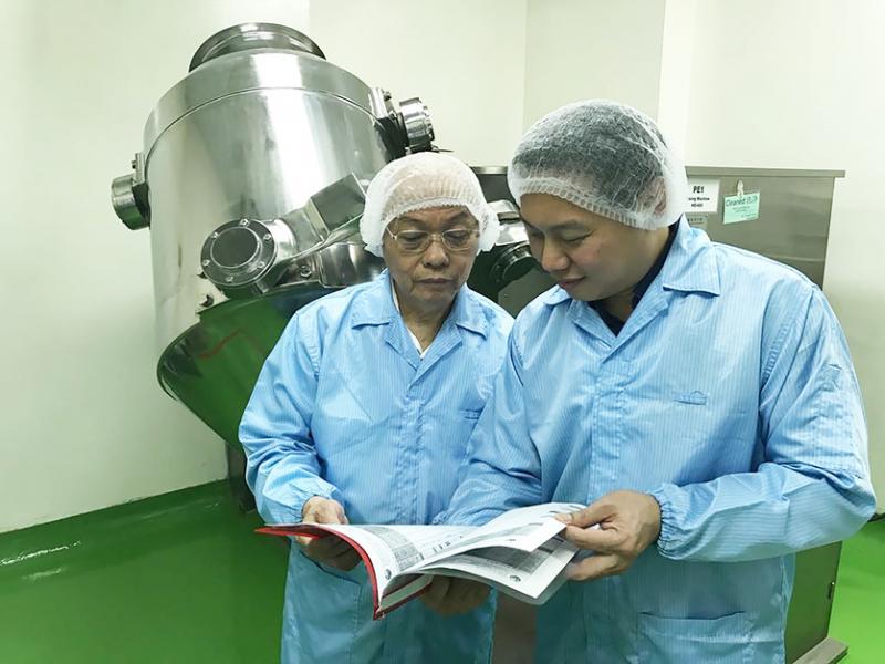 张竣杰（右）与退休中医师父亲张鸿武，在药厂研发和监督中药生产。（受访者提供）