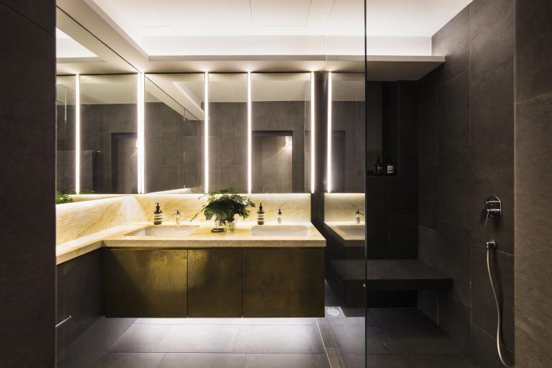 卫浴间的黄铜色系、客厅的地毯条纹都呼应前屋的黄铜色“光圈”铝屏。