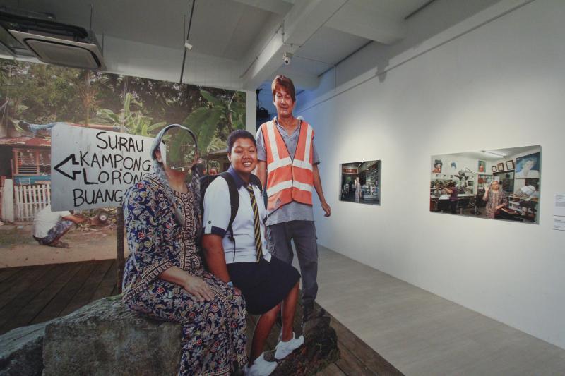 王良吟在《新女》穿上新航空姐制服，出现在罗弄万国马来甘榜（2011）。（新加坡美术馆提供）