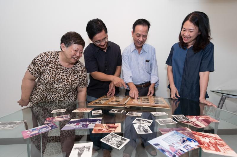韦俊韬医生(左二)与父母及太太曾美珠(右一)翻阅旧照片,回味成长的好时光。