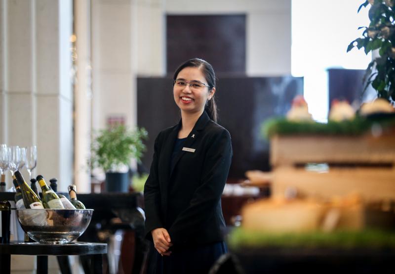 新加坡瑞吉酒店餐馆副经理郭娓圻在大学念会记。（叶振忠摄）